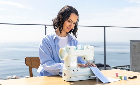 海辺のテーブルでEasy Liteを使用する女性